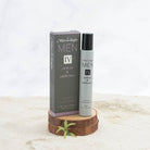 Men's fragrance bottle and packaging on a wooden stand with a white background